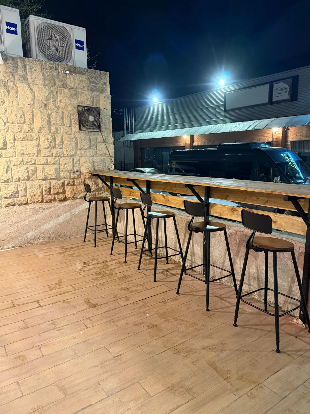 פינת ישיבה חיצונית עם דלפק עץ וכיסאות בר